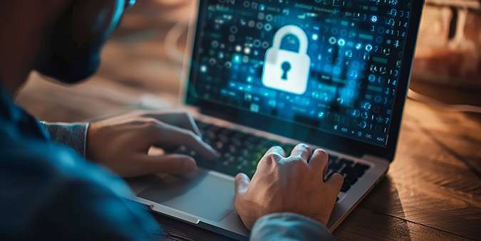 Person typing on a laptop with a digital lock icon on the screen, symbolizing cybersecurity or data protection.